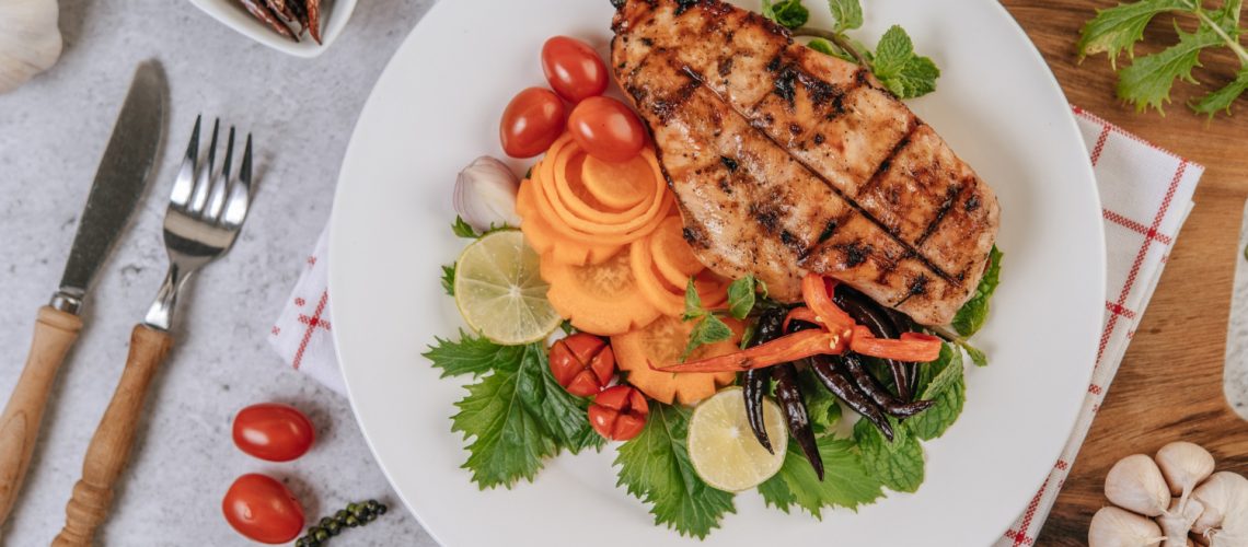 chicken-steak-with-lemon-tomato-chili-carrot-white-plate